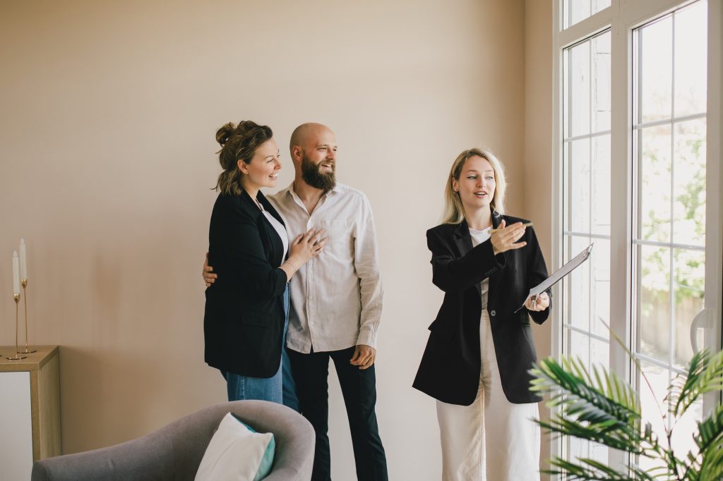 Real estate agent demonstrates a new apartment to a happy couple. Buying a property.